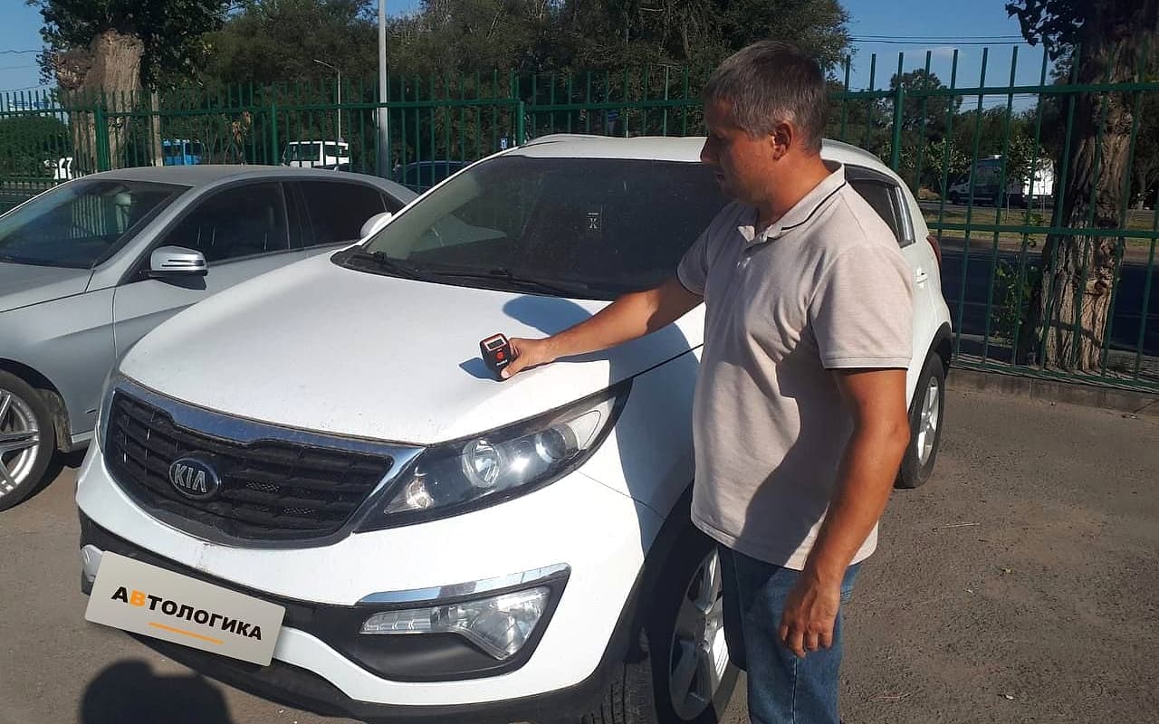 Специалист «АВТОЛОГИКА» проверяет толщину лакокрасочного покрытия автомобиля на площадке салона